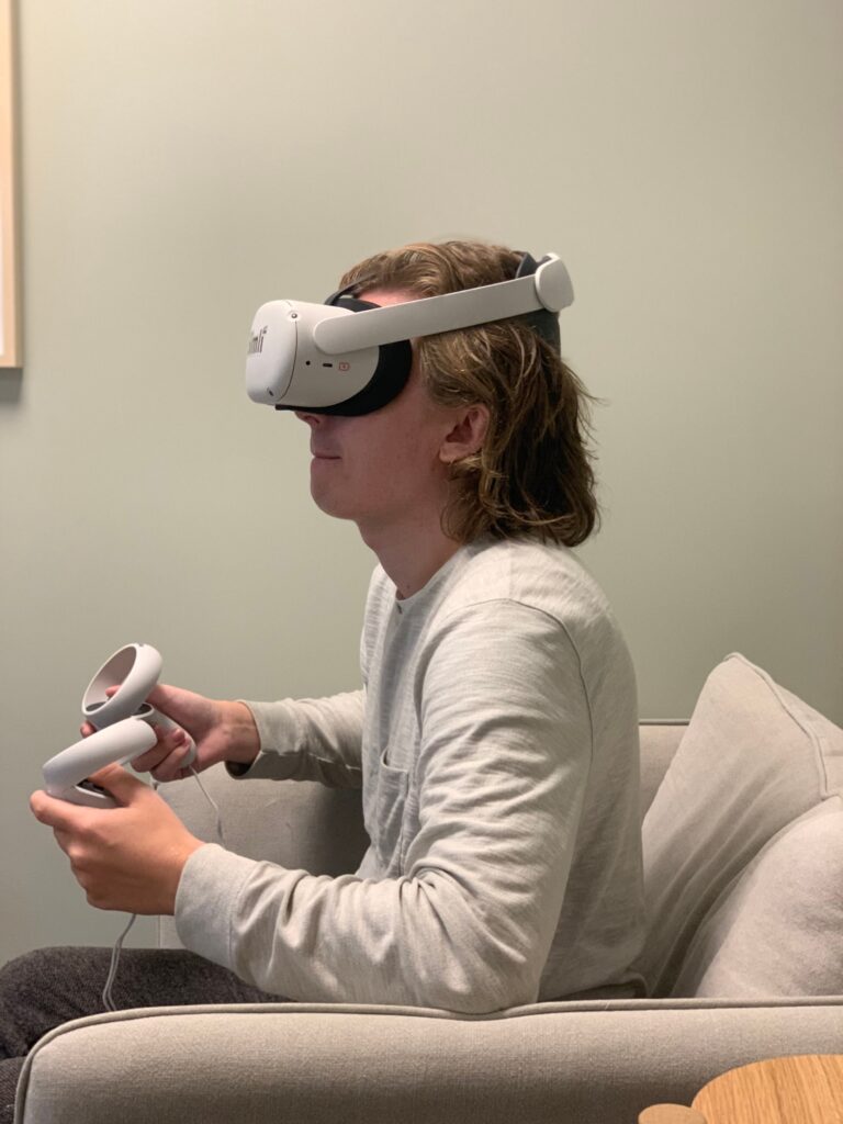 Ung mann med VR-briller og joysticks